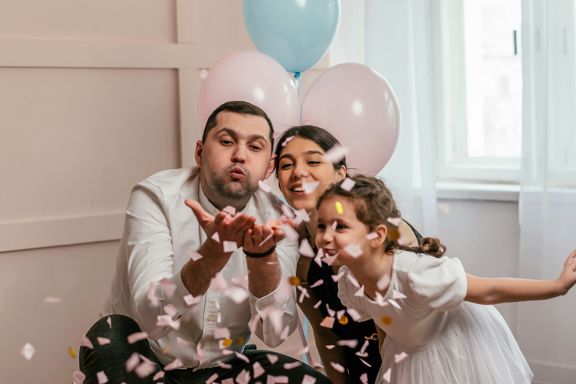 Expectant parents are having a gender reveal party, pink confetti.